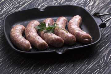 raw sausages on a  pan,  wooden background