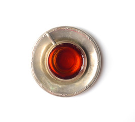 Vintage tea in a mug on a metal saucer on a white background
