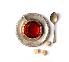Vintage tea in a mug on a metal saucer on a white background