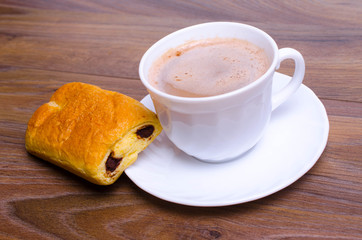 A cup of cappuccino coffee with slice of  cake