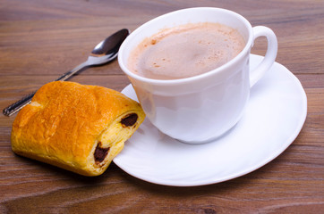 A cup of cappuccino coffee with slice of  cake