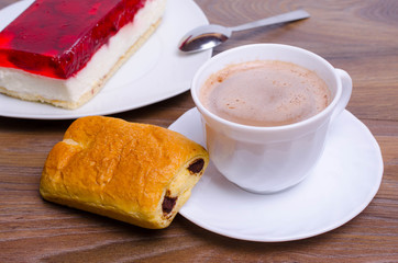 A cup of cappuccino coffee with slice of  cake