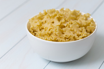 Raw campanelle pasta in a white bowl