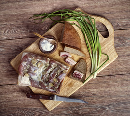 the salty bacon with onions and black bread on the wooden cuttin