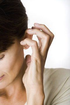 gros plan de visage de femme qui bouche son oreille