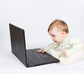 Cute baby boy with black laptop