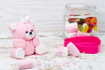 Fototapeta na wymiar Sugar pink bear cub and candies in jar