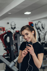 Beautiful girl in the gym with your phone