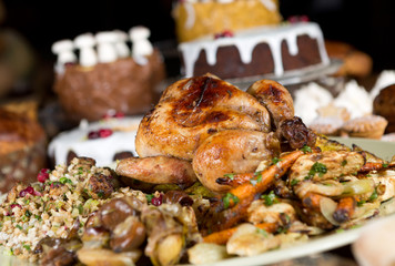 Unique beautiful christmas meal platter, with roast chicken and vegetables, surrounded by cakes, mince pies, fruit, bread and jam.