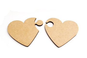 Two wooden hearts in form of puzzle on white background