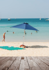 Wood table top on blurred blue sea and white sand beach