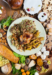 Unique beautiful christmas meal platter, with roast chicken and vegetables, surrounded by cakes, mince pies, fruit, bread and jam.