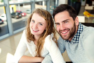 Beautiful couple in love sitting in cafe taking selfies