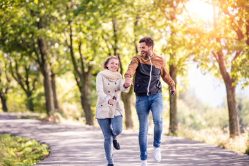 Fototapeta premium Couple in love in park on a walk, running