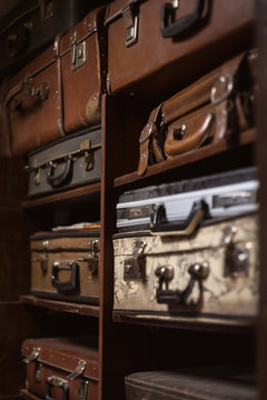 Selective focus photo of vintage suitcases stacked on the shelves