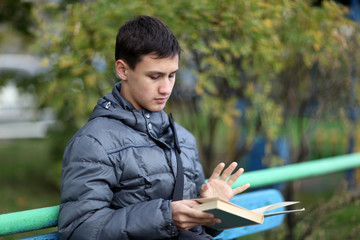 boy outdoors reading book