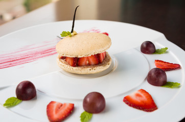 fresh strawberry and cream macaroons serves with grape and strawberry segments