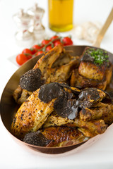 Roasted chicken with foie gras and truffle sauce, topped with sliced truffle, served in a metal pan. © dannyburn