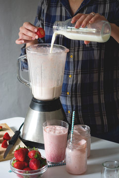 Man preparing a strawberry milkshake