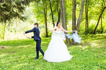 Wedding, love, relationships, marriage. Smiling bride and groom with blue smoke