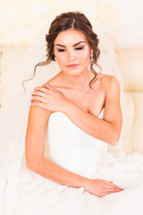 Beautiful bride in the interior sitting on couch