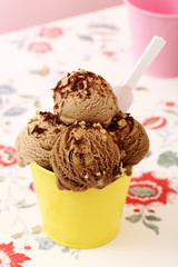 gelato alla nocciola in coppa di metallo giallo sfondo rosa