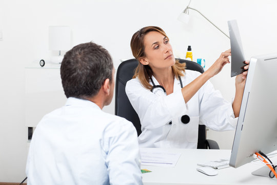 femme m&eacute;decin en consultation regardant des radiographies avec un patient 