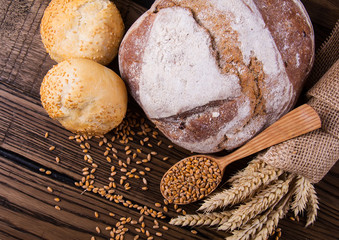 Assortment of baked bread on wooden table background