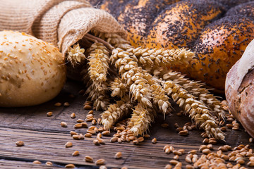 Assortment of baked bread on wooden table background