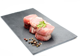 raw fillet medallions on the board of black basalt
