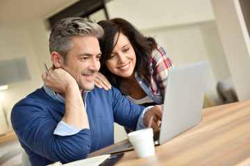 Couple at home using laptop computer