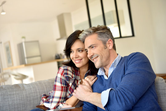 Middle-aged couple relaxing in sofa at home