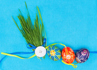 Blank, greeting easter card with green grass and easter eggs on blue background