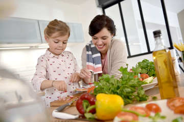 Mom and daughter cooking together in modern kitchen