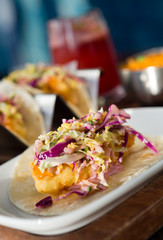 Mexican fried cod fish taco served with lettuce, red onion and sauce