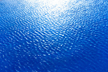 Blue pool water with sun reflections