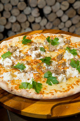 Gourmet goats cheese, mozzarella and truffle pizza served on a rustic wooden board