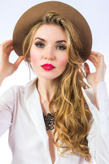 Beautiful girl in a hat portrait. Girl model holding his hat handed. Retro fashion style.