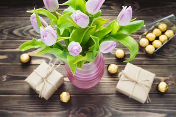 bouquet of purple tulip vase with gift boxes and candies