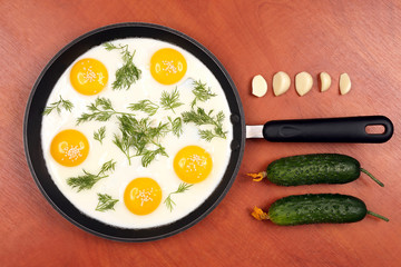 pan on the table with fried scrambled eggs with dill and cucumbe