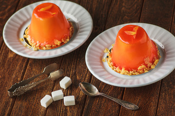 Mini orande mousse cakes covered with glaze. Modern european cak