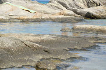 Sea rocks and shallow sea water of a bay