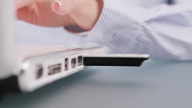 Woman inserts flash drive.