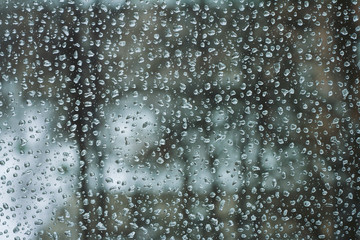 Naklejka na ściany i meble Water drops of rain on the window glass in gloomy weather. Street bokeh