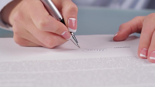Woman signing  contract.