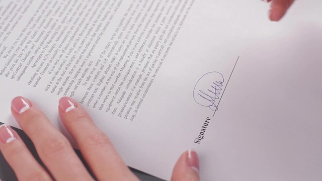 Business woman signs a agreement.
