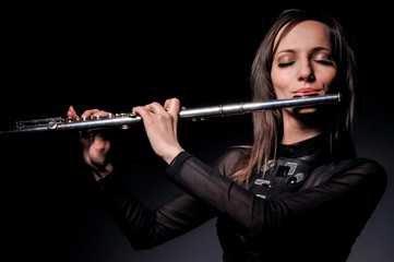 a young girl playing the flute © sushytska