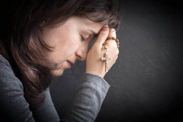 concentrated woman  with rosary