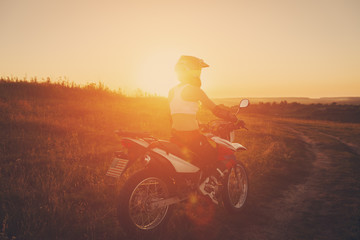 Obraz na płótnie Canvas Woman biker in sunset, female motorcycle.