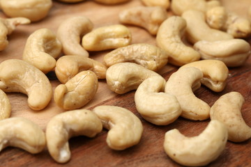 Raw cashew nuts on wooden table, detailed view